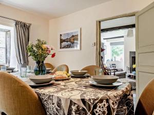 a dining room table with a vase of flowers on it at 4 Bed in Buttermere SZ090 in Buttermere