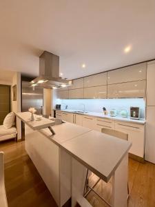 eine Küche mit weißen Schränken und einer Kücheninsel in der Unterkunft Στην ΚΑΡΔΙΑ ΤΗΣ ΠΟΛΗΣ - in the HURT OF THE TOWN in Tríkala