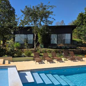 a house with a swimming pool and some chairs at Tupa Lodge in Puerto Iguazú