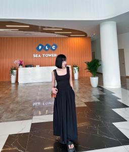 a woman in a black dress standing in a lobby at FLC Sea Tower - Sea view Quy Nhơn in Quy Nhon +111 photos