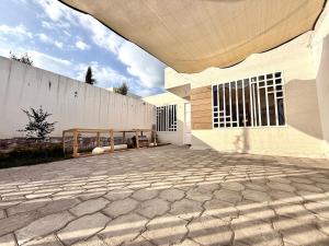 a large white building with a stone patio at Ideal para familia de 5 in Ibarra