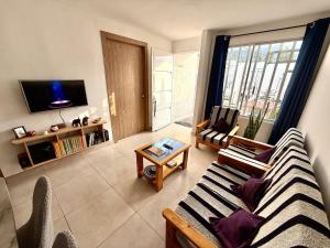 a living room with a couch and a tv at Ideal para familia de 5 in Ibarra