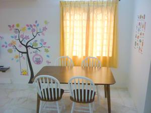 a dining room with a wooden table and three chairs at Super Cozy Homestay in Melaka