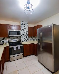 a kitchen with a stainless steel refrigerator and appliances at 3 Bdr Apartment close to Port of Spain in Diego Martin