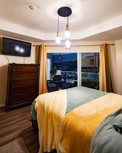 a bedroom with a large yellow bed and a living room at 3 Bdr Apartment close to Port of Spain in Diego Martin