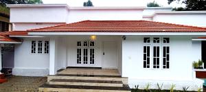 a white house with a red roof at Heaven Cloud Stay Hub Attappadi in Attappādi