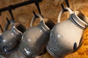 three silver vases are hanging on a rack at Le Jardin D' Épicure in Oderen