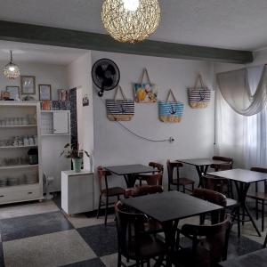 een eetkamer met tafels en stoelen en een kroonluchter bij Hotel Pousada Girassol- Balneário Riviera I in Matinhos