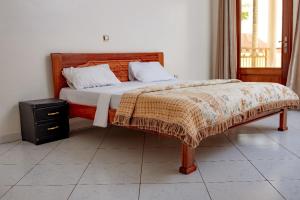 a bedroom with a large bed with a wooden headboard at Elegant Villa Apart in Kigali