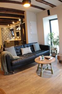 a living room with a black leather couch and a table at Piedra y Luz in Buendía