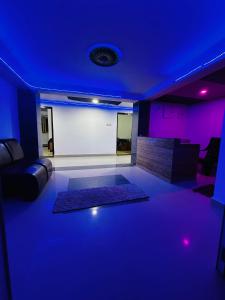 a living room with purple lighting and a couch at Sunrise Resort in Araku