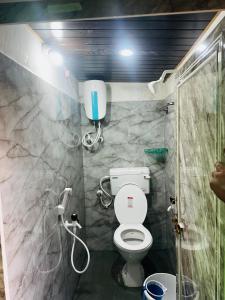a small bathroom with a toilet and a shower at Sunrise Resort in Araku