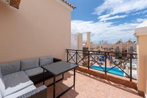 un balcon avec un canapé et une vue sur une piscine dans l'établissement Terrace & Pool Hideaway Apartment, à Adeje