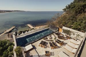 een uitzicht op een zwembad met stoelen en de oceaan bij Dayone Kilyos Hotel in Kilyos