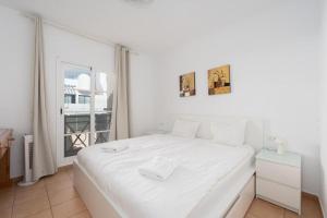 une chambre blanche avec un lit blanc et une fenêtre dans l'établissement Terrace & Pool Hideaway Apartment, à Adeje