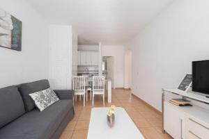 un salon avec un canapé et une salle à manger dans l'établissement Terrace & Pool Hideaway Apartment, à Adeje