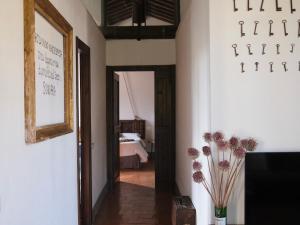 a hallway with a room with a bed and a vase of flowers at Country Loft at Palazzo di Bagnaia in Castel del Piano +26 photos