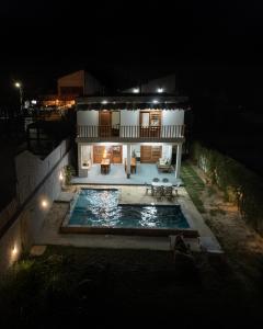 a house with a swimming pool at night at Casa da GabiLu in Itapipoca