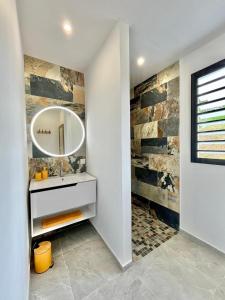a bathroom with a sink and a mirror at Villa Aloha - classée 5 étoiles - avec piscine in Les Trois-Îlets +26 photos