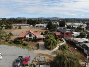 ein Haus mit davor geparkten Autos in der Unterkunft Hostal Rama Fueguina in Teodoro Schmidt