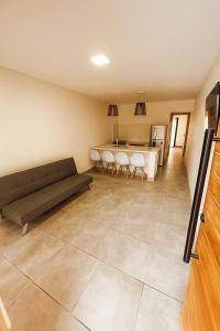 ein Wohnzimmer mit Sofa und Tisch in der Unterkunft Departamentos a estrenar, zona parque in Necochea