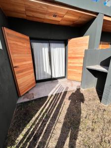 ein Schatten einer Person, die vor einem Haus steht in der Unterkunft Departamentos a estrenar, zona parque in Necochea + 1 Foto