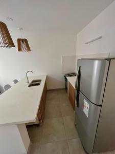 eine Küche mit einem Kühlschrank aus Edelstahl und Arbeitsplatten in der Unterkunft Departamentos a estrenar, zona parque in Necochea