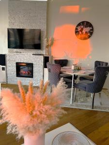 パランガにあるBlueSeaPearl apartamentai Palanga, Šventojiのテーブルと暖炉のあるリビングルーム