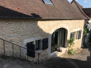 a stone building with an archway and a door at Maison en pierre in Saint-Sozy