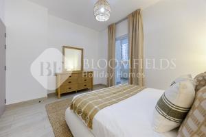 a bedroom with a bed and a mirror and a dresser at Bloomfields Comfortable 1Br In Water Edge in Yas Island +8 photos