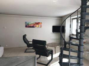 a living room with two chairs and a table at Maison en pierre in Saint-Sozy