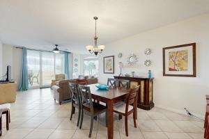 ein Esszimmer und ein Wohnzimmer mit Tisch und Stühlen in der Unterkunft Beach Colony Resort West 1E in Navarre