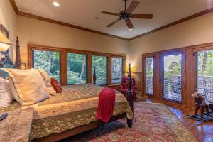 a bedroom with a bed with a fan and windows at Amitola at Yonahlossee in Boone +63 photos