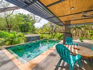 a patio with a table and chairs and a swimming pool at The Wave House in Santa Cruz