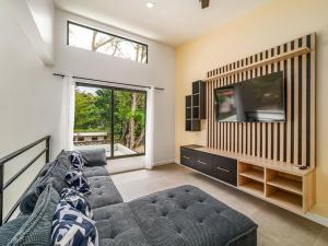 a living room with a couch and a flat screen tv at The Wave House in Santa Cruz