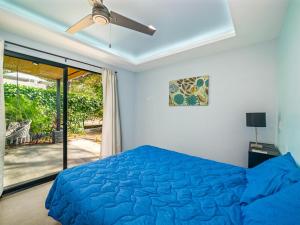 a bedroom with a blue bed and a ceiling fan at The Wave House in Santa Cruz +22 photos