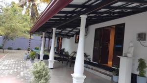 a porch of a house with a wooden roof at Crystal house in Weligama