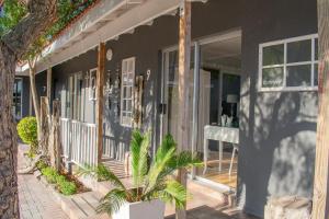 SummerstrandにあるVillaVin at 26 Richardsonのポーチにヤシの木が置かれた家