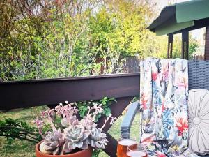 een balkon met een tafel met planten en een gordijn bij Cinnamon & Sage Country Cabins in Dullstroom +2 foto's