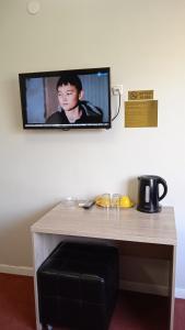 a tv hanging on a wall with a table at КзО in Shymkent