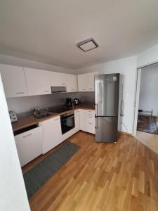 een keuken met witte kasten en een roestvrijstalen koelkast bij Ferienwohnung Karin in Schwaz