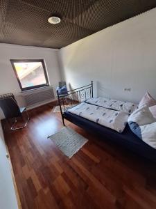 een slaapkamer met een bed in een kamer met houten vloeren bij Ferienwohnung Karin in Schwaz