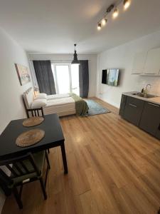 une chambre avec un lit et une table et une cuisine dans l'établissement Fred&Moris Apartments, à Poznań