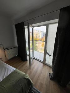 une chambre avec une grande porte vitrée donnant sur un balcon dans l'établissement Fred&Moris Apartments, à Poznań