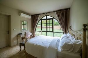 une chambre avec un lit et une grande fenêtre dans l'établissement My Ozone Villa Khaoyai มายโอโซน วิลล่า เขาใหญ่, à Ban Sap Setthi