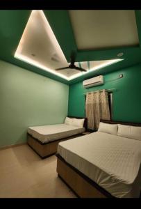 瓦拉纳西Hotel Seth Villas的配有绿色墙壁和天花板的客房内的两张床 更多3张照片