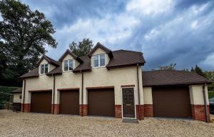 a large house with four garage doors in a driveway at New Modern Studio in Chandlers Ford with Parking in Chandlers Ford