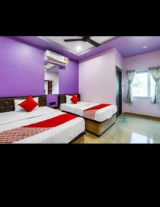 瓦拉纳西Hotel Seth Villas的紫色墙壁的房间里有两张床