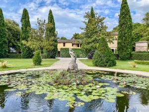 a garden with a pond with water lilies at Country Loft at Palazzo di Bagnaia in Castel del Piano
