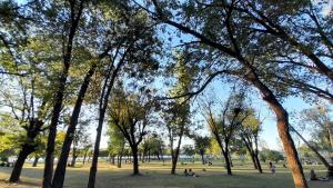 a park with trees and people sitting in the grass at Duplex Villa Carlos Paz in Villa Carlos Paz +3 photos